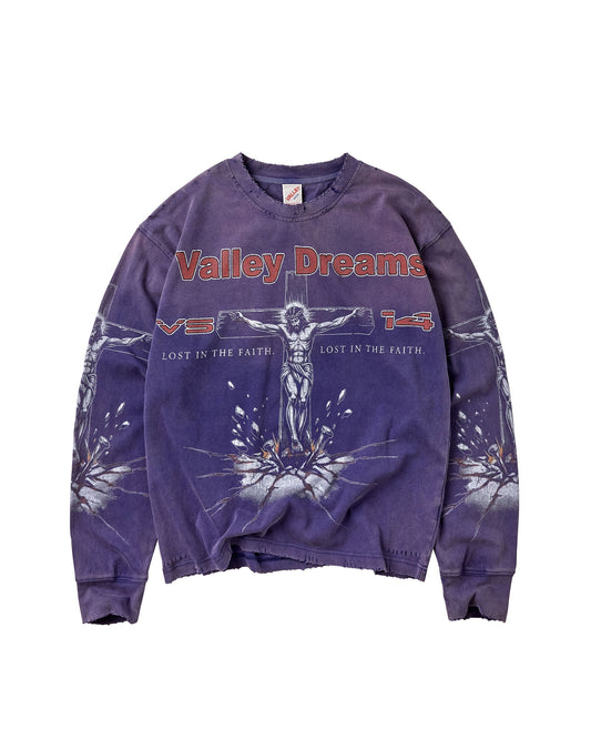 A purple mineral-wash crewneck sweatshirt featuring a graphic of Jesus on the cross with the text 'Valley Dreams' in red across the chest, displayed flat against a white background.